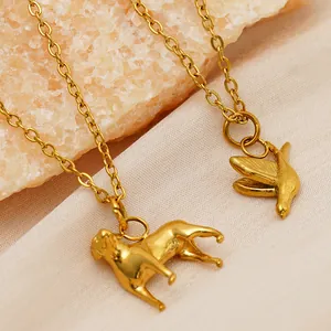 Close-up detail showing 18k gold plated stainless steel dog and bird pendant necklace charms