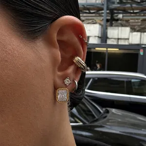 Detailed view of elegant emerald-cut zircon earrings featuring a ribbed gold-tone border frame.