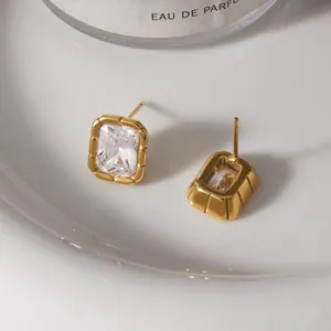 Close-up of gold-plated stainless steel earrings with rectangular zirconia and ribbed edges