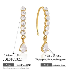 Detail view of gold stainless steel earrings with sparkling teardrop zircon pendants.