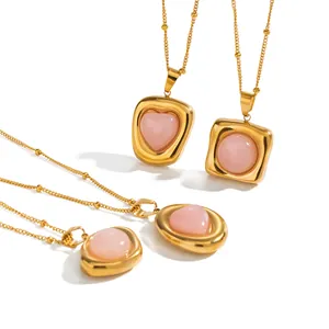 Elegant stainless steel necklace with pink crystal heart and round pendants in gold frames.
