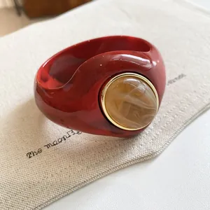 Chunky red acrylic bangle with amber resin stone inlay and gold rim detail