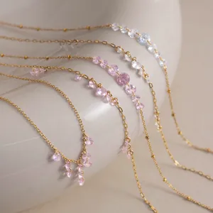 Close-up of 18K gold-plated necklaces with gradient pink and white zircon tassels.