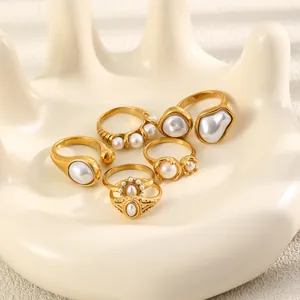 Détail de bagues en acier inoxydable plaqué or 18 carats avec perles élégantes.