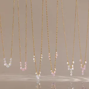 Detail view of hanging 18K gold plated necklaces with pink and white zircon tassels.