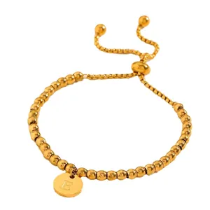 Bracelet élégant en perles d'acier doré avec un pendentif rond gravé de la lettre E