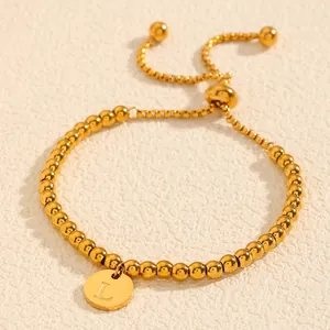 Détail du bracelet en perles d'acier inoxydable doré avec breloque initiale lettre L