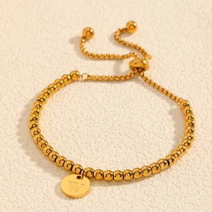 Gros plan d'un bracelet en acier titane doré avec pendentif de la lettre W