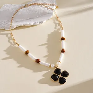 Dettaglio macro della collana retrò con ciondolo a fiore in resina nera e legno