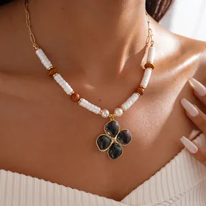 Primo piano di collana retrò a fiori con perle e legno indossata da una modella