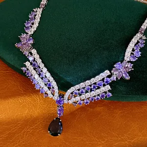 Nahaufnahme einer luxuriösen lila Edelsteinkette mit Tropfenanhänger und Blumendetail