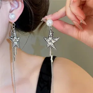 Nahaufnahme von glitzernden Stern-Quasten-Ohrringen mit Perlensteckern