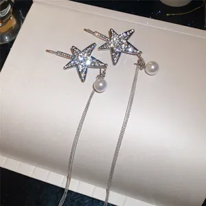 Detailaufnahme einer glitzernden Stern-Haarklammer mit langen Quasten und Perle