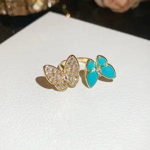 Macro view of gold ring featuring two butterflies with zircons and turquoise enamel