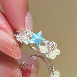 Detailed view of a vintage palace style ring with blue star, pearls and zircons