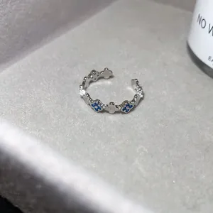 Macro view of vintage silver open ring with blue zircon four-leaf clover pattern
