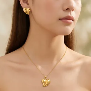 Élégant ensemble collier et boucles d'oreilles cœur plaqué or 18 carats en acier sur modèle