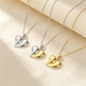Gros plan de colliers cœur 3D en acier inoxydable plaqué or 18 carats en trois finitions
