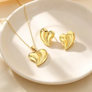 Gros plan détaillé d'un ensemble de bijoux en forme de cœur 3D en acier plaqué or 18 carats