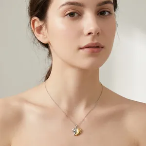 Gros plan d'un collier avec pendentif cœur bicolore plaqué or 18 carats porté par un mannequin