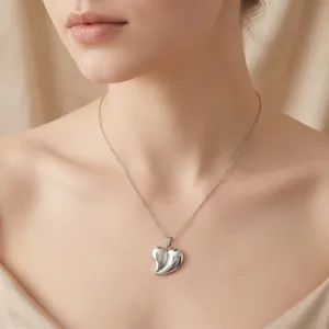 Vue détaillée d'un élégant collier avec pendentif cœur 3D en argent porté par un mannequin