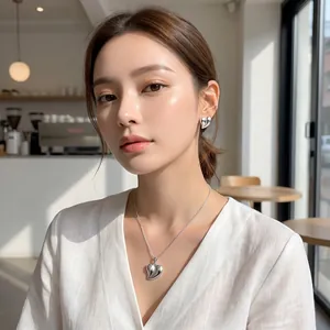 Mannequin asiatique élégant portant un ensemble collier et boucles d'oreilles cœur argent