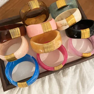 Set of chunky marbled resin bangles with elegant gold wire wrapping in various colors