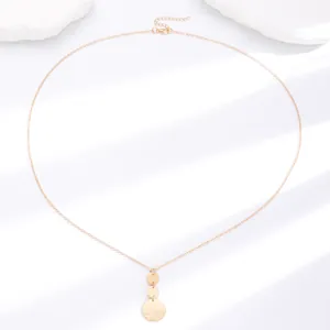 Detailed view of gold necklace with triple geometric circular discs and hammered texture