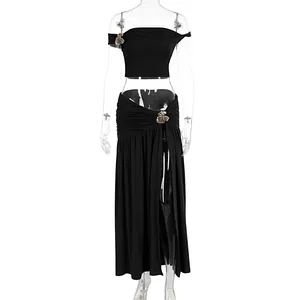 Close-up of black two-piece set with metallic flower details and high slit skirt.