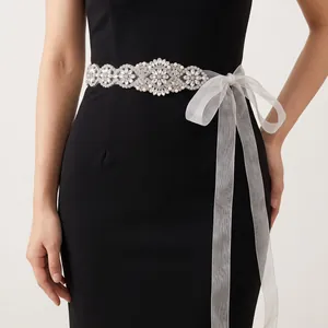 Hand-stitched bridal belt with sparkling rhinestones and white ribbon on evening dress