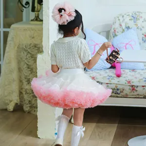 Elegant back view of a young girl wearing a fluffy pink and white layered mesh tutu skirt