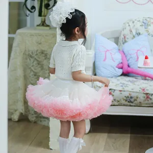 Rear view of a girl wearing a fluffy pink and white layered mesh tutu skirt in a cozy room