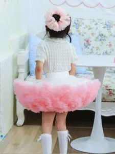 Back view of girl wearing a fluffy pink tutu skirt and matching floral hair accessory