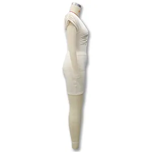 Vue latérale d'une élégante mini-robe moulante sans manches crème avec des fronces