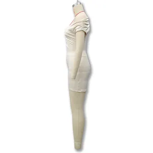 Vue latérale de l'élégante robe mini moulante sans manches à épaules dénudées crème