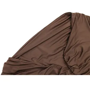 Gros plan sur le tissu élastique marron avec détails froncés sur une robe