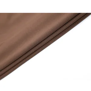 Gros plan macro montrant la texture du tissu extensible marron pour robe moulante femme