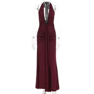 Front view of an elegant burgundy halter neck backless long dress with ruched details