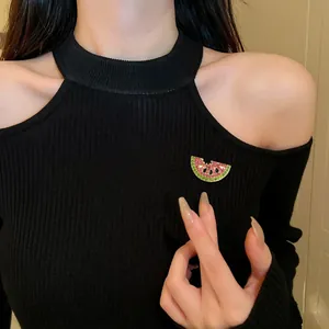 Close-up of cute pink and green crystal watermelon brooch pin on black knit top