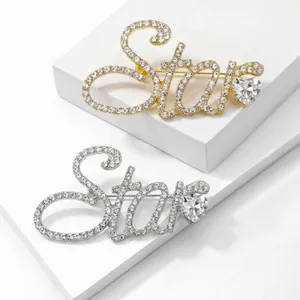Gros plan détaillé des élégantes broches lettres 'Star' en strass, finitions or et argent