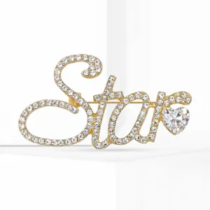 Vue détaillée d'une broche 'Star' dorée ornée de strass étincelants et d'une gemme en cœur