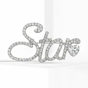 Vue détaillée d'une broche en strass argenté en forme de mot Star avec cristal en cœur.