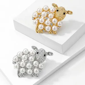 Detail of elegant sheep brooches with white pearls and gold/silver finish