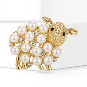 Close-up of a gold-plated sheep brooch with white pearls and sparkling rhinestones