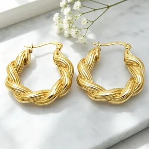 Nahaufnahme eleganter, 18 Karat vergoldeter Creolen aus Edelstahl mit gedrehtem Design.