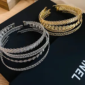 Dettaglio ravvicinato della trama intrecciata dei girocolli in metallo color oro e argento