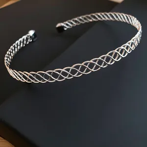Elegante girocollo in metallo intrecciato argento con design a spirale traforato.