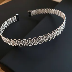 Primo piano di un girocollo in maglia d'argento ondulata con design intrecciato elegante