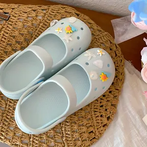 Close-up of light blue clog sandals decorated with sea shell and starfish DIY charms