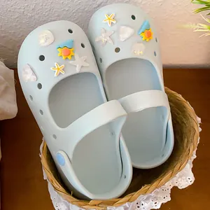 Detail of marine-themed starfish and shell charms on light blue clog shoes